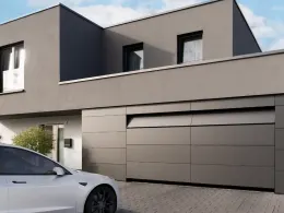 Dunkles Wohnhaus mit anthrazitfarbenem Garagentor und Carport