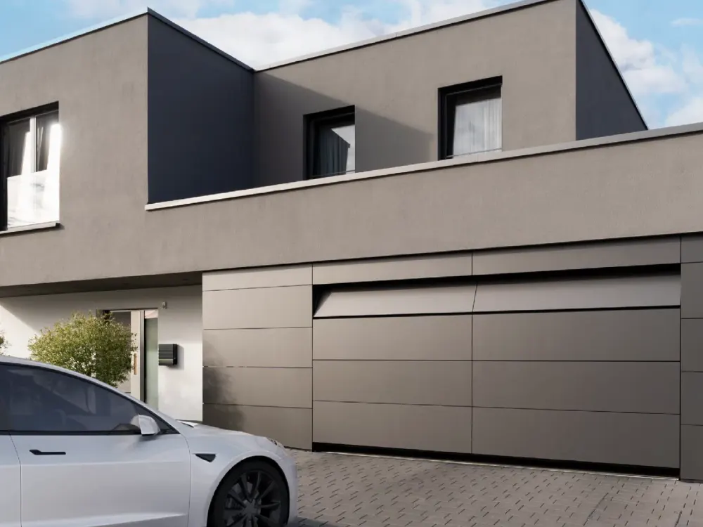Dunkles Wohnhaus mit anthrazitfarbenem Garagentor und Carport