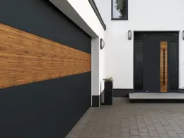 Hausfassade aus dunklem Putz und Holzlamellen mit bündig eingesetztem Garagentor