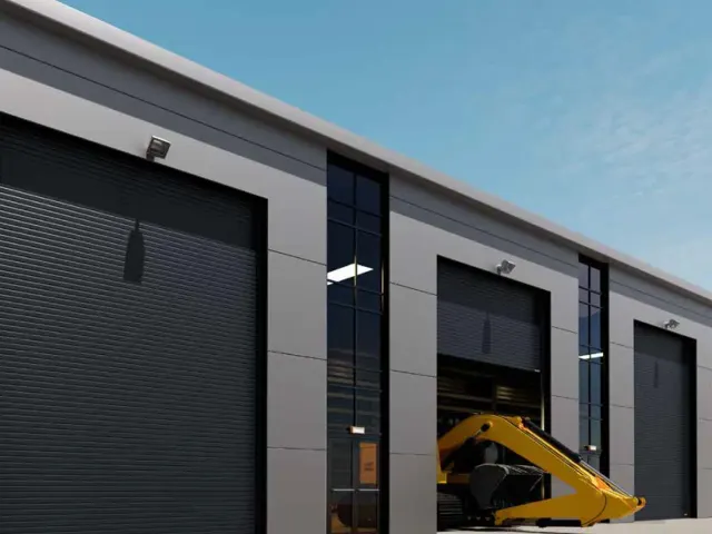 Gewerbehalle mit dunkler Fassade und mehreren großformatigen Industrietoren