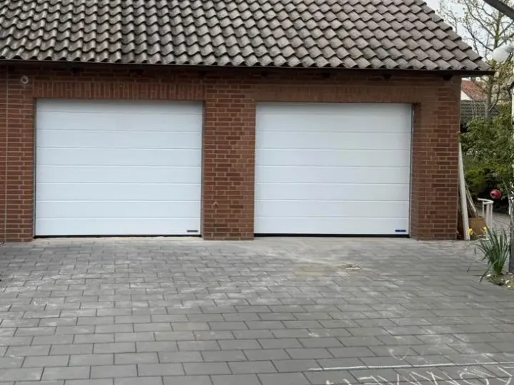 Dieselbe Klinkergarage mit zwei weißen Hörmann Sektionaltoren